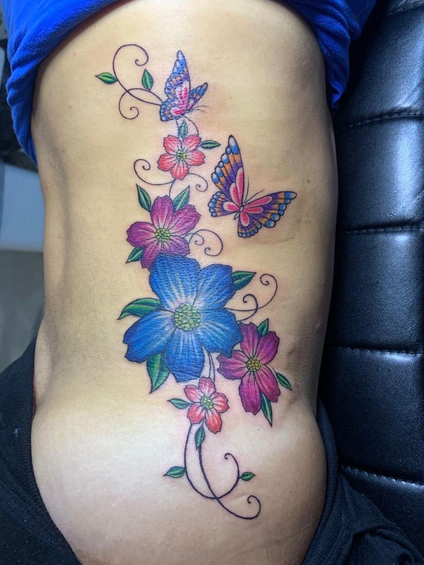 Tatuagem colorida floral nas costelas