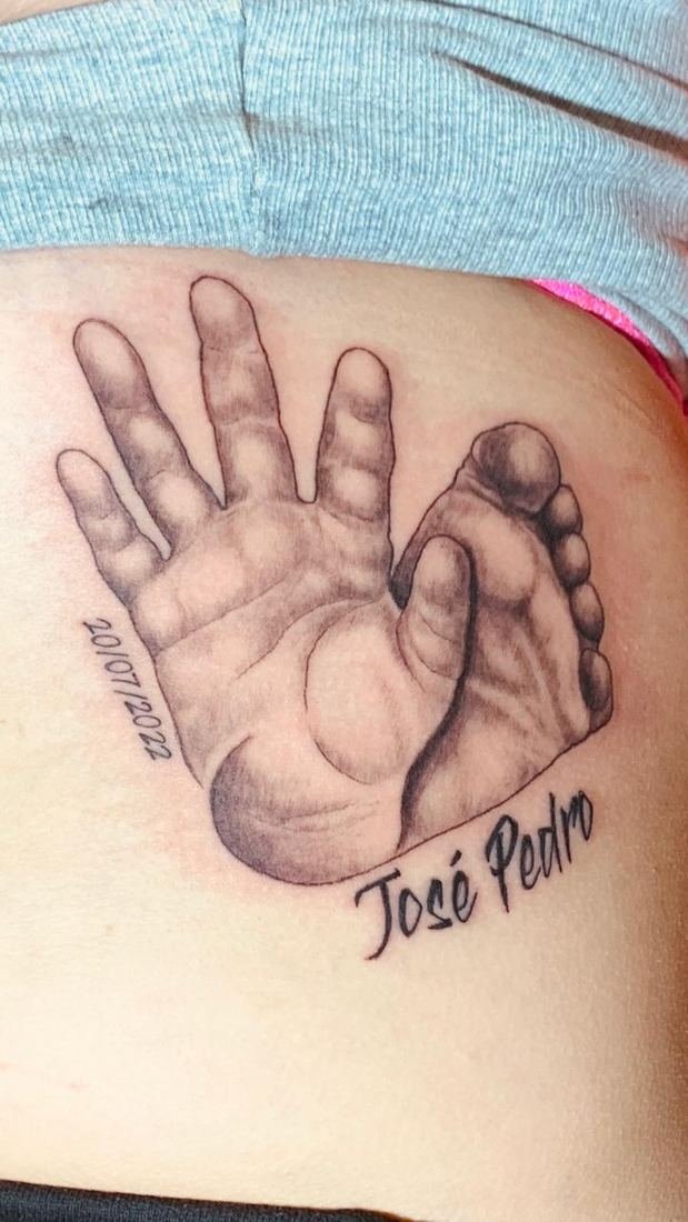 Tatuagem fineline de mãozinha de bebê com nome