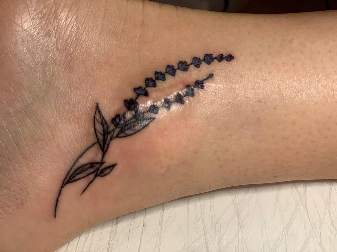 Tatuagem fineline floral na coluna