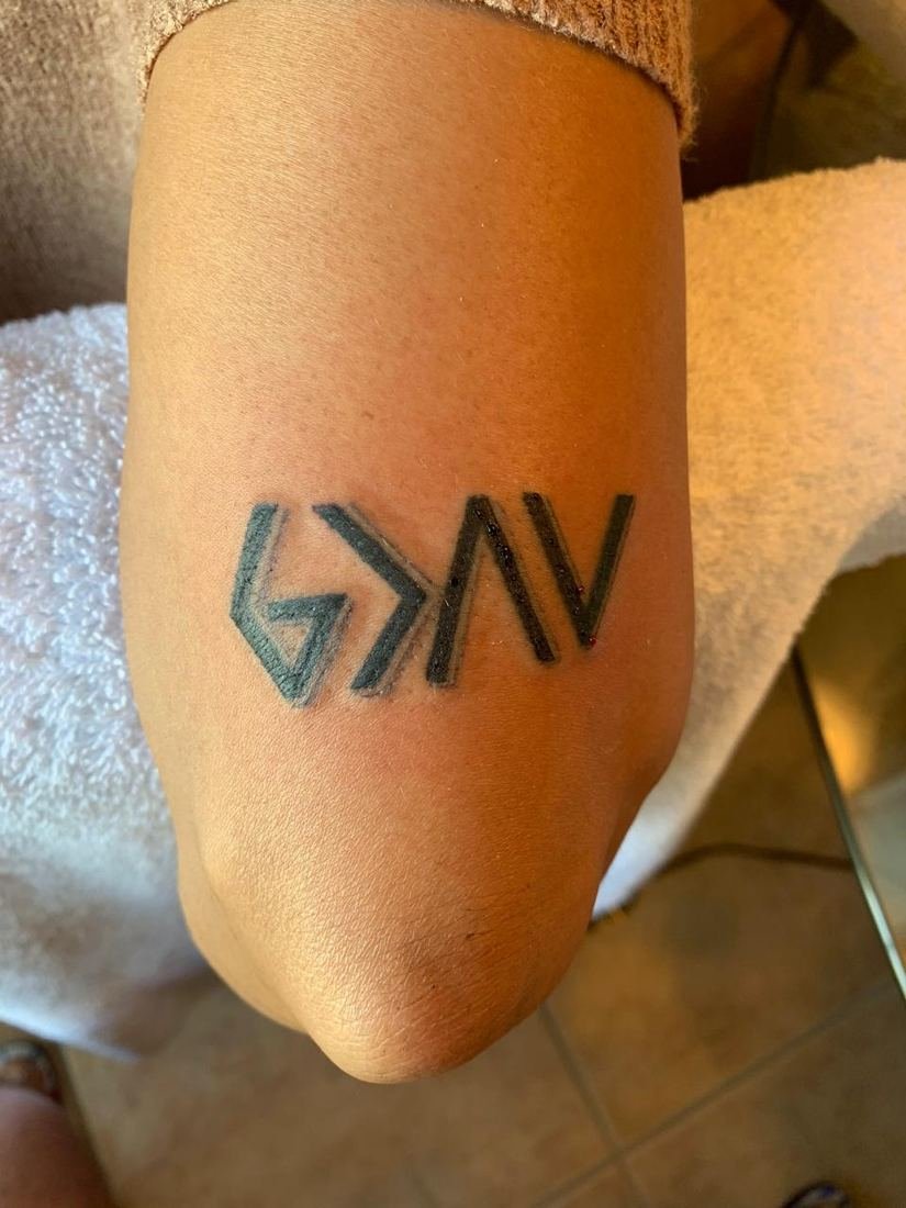 Tatuagem de lettering estilizada no braço
